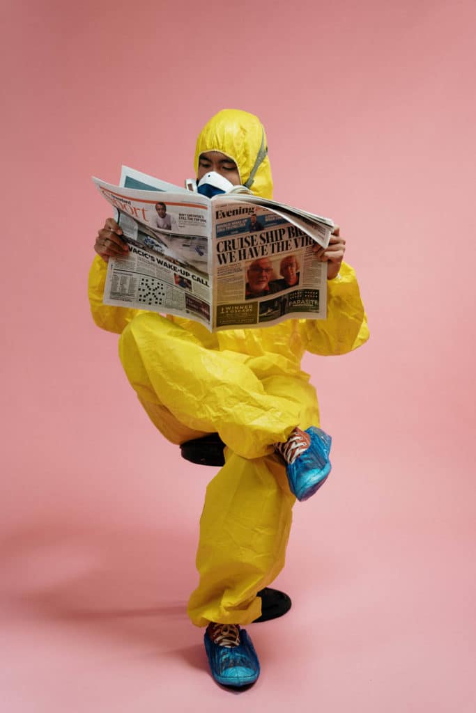 man in yellow protective suit holding a newspaper 3951350 683x1024 1